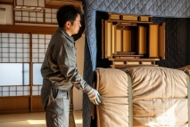 仏壇を布で覆う作業員